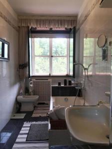 塞拉瓦莱皮斯托耶塞CASA Lux的一间带水槽和浴缸的浴室以及窗户。