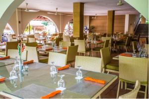 普拉亚科罗纳多Private Owned Suite at Coronado Luxury Suite Hotel & Golf Course的用餐室配有桌椅和橙色餐巾