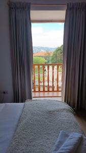 卡哈马卡Hotel Aural的一间卧室设有一张床,享有阳台的景色
