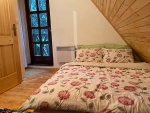 莫斯塔尔Moonica Rujiste的一间卧室配有一张带花卉棉被的床