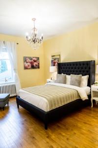 Bécancour贝肯考特庄园酒店的一间卧室配有一张大床和一个吊灯。