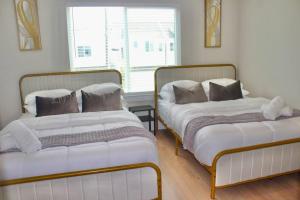 休斯顿Modern Minimalist Luxury Retreat的两张睡床彼此相邻,位于一个房间里