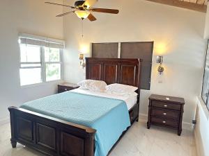 WoodlandsOceanfront 3 bedrooms, 4beds, AC, WiFi, luxury villa的一间卧室配有一张床和吊扇