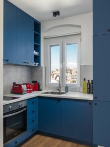 Ágios RókkosCorfu Lux City的蓝色的厨房,配有水槽和窗户