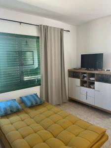 普拉亚布兰卡Casa Noas的一间卧室配有一张床和一台平面电视