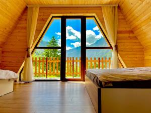 佩奇Villa Dardania的木屋内设有一间带大窗户的卧室