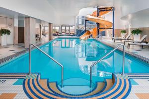 卡尔加里卡尔加里奥克莱尔喜来登套房酒店的一个带滑梯的游泳池