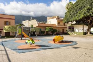 圭马尔Casa Rural Teresita Entera Tranquila Llena de Bienestar的停车场内一个带两个游戏设备的游乐场