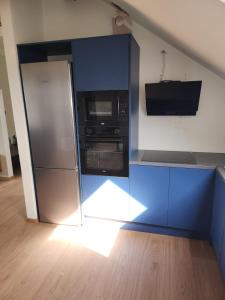 奥古斯图Blue Door Apartment Loft的厨房配有冰箱和微波炉。