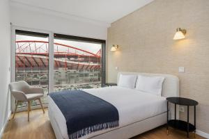 里斯本WHome Urban Retreat w/Parking, Elevator & AC by Benfica Stadium的一间卧室配有一张床,享有体育场的景色