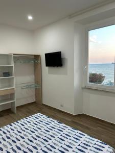 奇维塔韦基亚Stella di Mare的白色的客房设有窗户和平面电视。