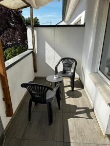 博霍尔特BocholtApartments的阳台配有两把椅子、一张桌子和一把椅子