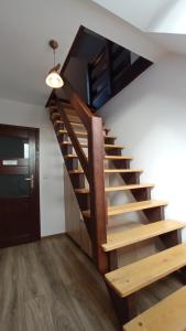 斯罗姆韦斯尼Noclegi u Bartka的木楼梯,位于带门的房间