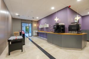 布雷达Leonardo Hotel Breda City Center的餐厅拥有紫色的墙壁和1个带紫外线的台面。