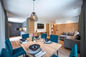 奥蒂塞伊Apartments LaBar的用餐室以及带木桌和蓝色椅子的客厅。