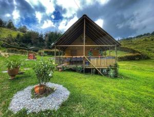 El PeñolEspectacular Cabaña Loft en Guatape - Jacuzzi的草场上的小木屋,有房子