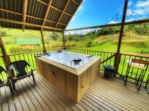 El PeñolEspectacular Cabaña Loft en Guatape - Jacuzzi的房屋甲板上的热水浴池