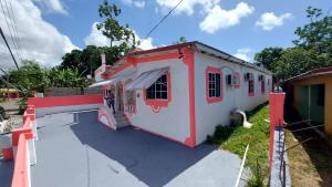 BelfastCharming 1-Bedroom House in St Thomas Jamaica的一座红色和白色的建筑,一个人站在外面