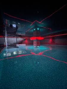 普里什蒂纳Hotel Sara & SPA的夜间游泳池,有红灯