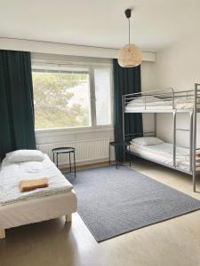 图尔库Woodpecker Avenue Family Apartment Turku的一间卧室设有两张双层床和一扇窗户。