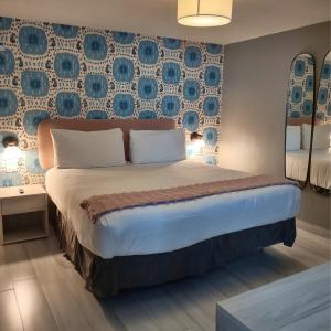圣胡安Trópica Beach Hotel的一间卧室配有一张蓝色和白色壁纸的大床