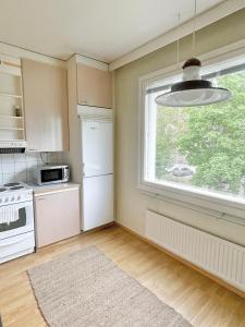 图尔库Woodpecker Avenue Family Apartment Turku的厨房配有白色冰箱和窗户。