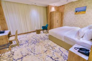 乌姆莱季Wissam Al-Hawra Hotel的酒店客房,配有一张床、一张桌子和椅子