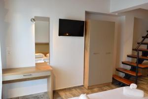 克里斯阿穆迪亚Dioscuri Deluxe Apartments的卧室设有壁挂式电视和衣柜。