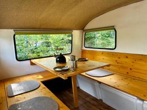 施莱茨Auszeit im Wald direkt am See的拖车后面的木桌,带两个窗户