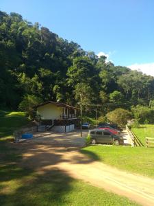 伊泰帕瓦Fazenda Piloes的山前有停车位的房子
