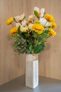 诺瓦利娅Bed&Breakfast Novalis的花瓶,上面有黄白花
