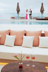 普拉亚登博萨AMA Ibiza的沙发旁的桌子上放两杯葡萄酒