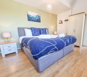 米尔顿凯恩斯Milton Keynes Modern City House的一间卧室配有一张带蓝色棉被的床