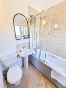 米尔顿凯恩斯Milton Keynes Modern City House的浴室配有卫生间、盥洗盆和浴缸。