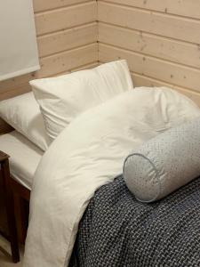 埃斯波Sauna cabin in the heart of Nuuksio National Park的一张带白色床单和枕头的床