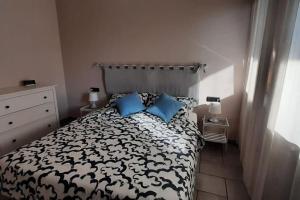 博尔戈马内罗Blue House的一间卧室配有黑色和白色的床以及蓝色枕头