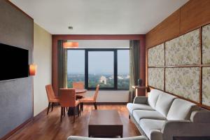 新德里新德里艾美酒店 的客厅配有沙发和桌子