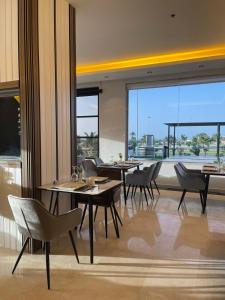 乌姆莱季Wissam Al-Hawra Hotel的餐厅设有桌椅和大窗户。