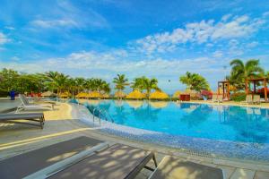 圣玛尔塔Apartasuites Samaria - Club de Playa的一座棕榈树大型游泳池,