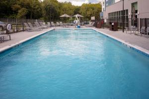 奥兰多TownePlace Suites by Marriott Orlando Airport的大楼内带椅子的大型游泳池