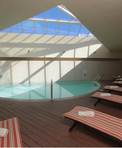 巴拉斯港巴拉斯港雷迪森酒店的一座带玻璃天花板的建筑中的游泳池