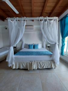 卡塔赫纳hotel 3 banderas Manzanillo del Mar的一间卧室配有白色窗帘的床