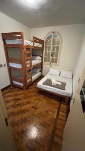 贝洛奥里藏特Nuh Hostel - Lourdes的客房设有两张双层床,铺有木地板。
