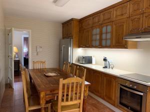 卡尔达斯·德·雷斯Home Sweet Home的厨房配有木桌和木橱柜。