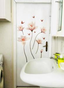 CastelsaracenoLa Casa dei Panorami的浴室设有白色水槽,墙上挂着粉红色的鲜花