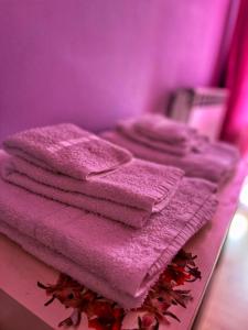 CastelsaracenoLa Casa dei Panorami的一张桌子上摆着一堆粉红色的毛巾