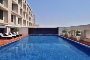 斋浦尔Four Points by Sheraton Jaipur, City Square的一座带椅子的酒店游泳池,一座建筑