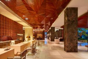 塞米亚克巴厘岛塞米亚克福朋喜来登酒店的大楼内带桌椅的大堂