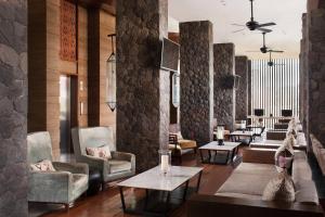 塞米亚克巴厘岛塞米亚克福朋喜来登酒店的大厅,在大楼里摆放着长沙发椅和桌子