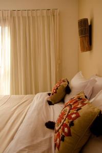 费尔南多 - 迪诺罗尼亚Casa Makaira的一张带两个枕头的白色床和窗户